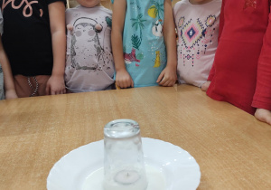 dzieci obserwuja gaśnięcie świeczki
